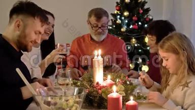 <strong>圣诞快乐</strong>，<strong>圣诞快乐</strong>！ 幸福的家庭在家吃晚饭。 人民观念